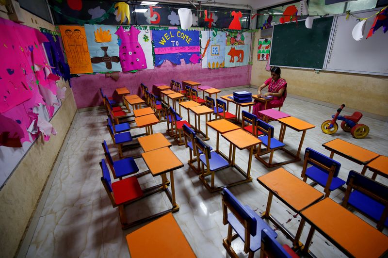 © Reuters. FILE PHOTO: A teacher sits in an empty classroom after Tamil Nadu state government ordered the closure of primary schools across the state amid coronavirus fears, in Chennai