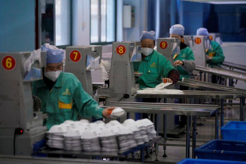 © Reuters. FOTO DE ARCHIVO: Se ve a los trabajadores en una línea de producción fabricando máscaras en una fábrica en Shanghái, China