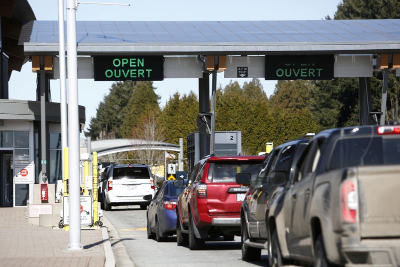 © Reuters. FILE PHOTO: Drivers wait to cross through Canadian customs at the Canada-US border near the Peace Arch Provincial Park