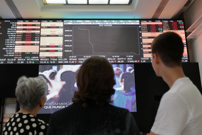 © Reuters. Pessoas observam painel na B3, a bolsa de valores de São Paulo