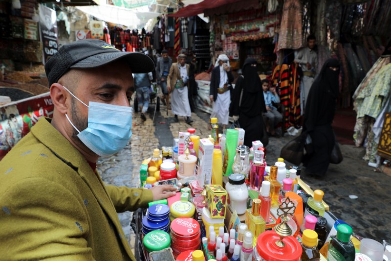 © Reuters. A street vendor selling cosmetic products wears a protective face mask amid fears of the spread of the coronavirus disease (COVID-19), at a market in the old quarter Sanaa, Yemen