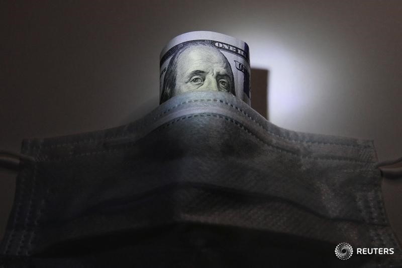 © Reuters. A U.S. dollar banknote is pictured behind a protective mask in this illustration