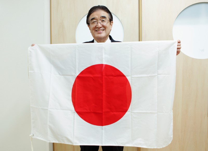 © Reuters. Tadamasa Fukiura, flag supervisor and consultant to Tokyo 2020 Olympic and Paralympic Games organisers, holds a Japanese national flag