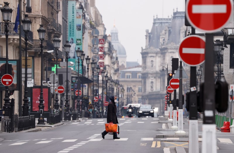 © Reuters. A man wearing a protective face mask crosses the deserted Rue de Rivoli in Paris