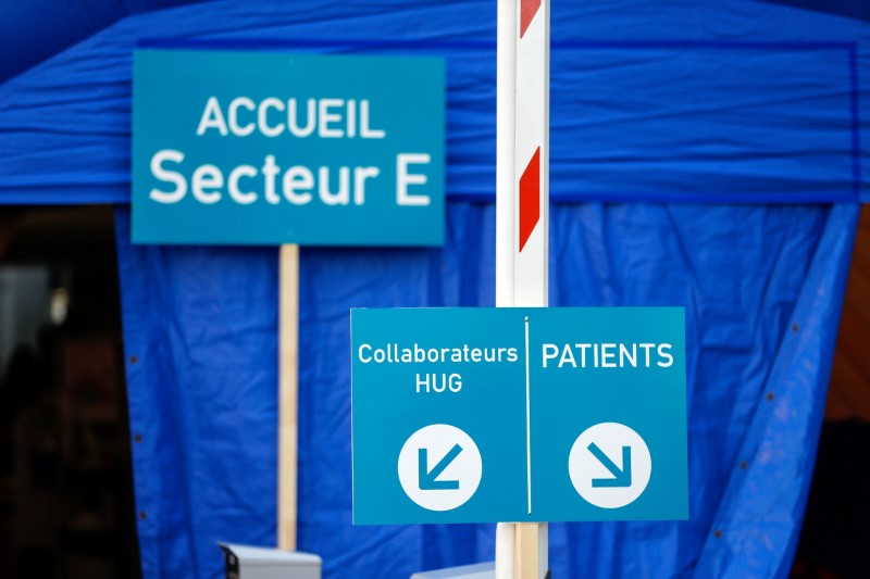 © Reuters. FILE PHOTO: Signs are seen on a medical screening tent for coronavirus testing outside HUG in Geneva