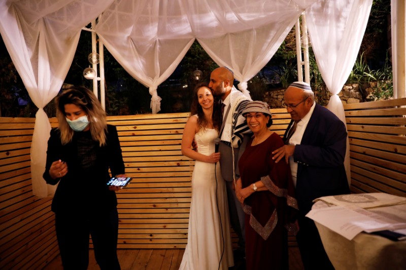 © Reuters. Israeli couple Roni Ben-Ari and Yonatan Meushar, embrace as they get married at Ein Hemed Forest Wedding Venue, in Ein Hemed, Israel