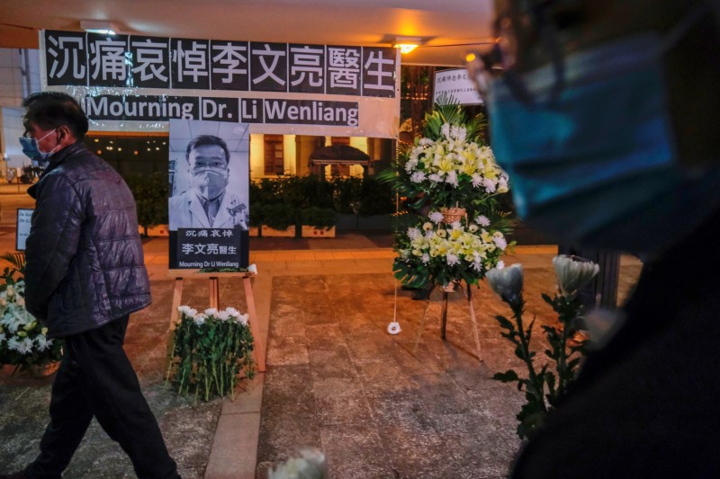 © Reuters. FILE PHOTO: People wearing masks attend a vigil for late Li Wenliang, an ophthalmologist who died of coronavirus at a hospital in Wuhan, in Hong Kong