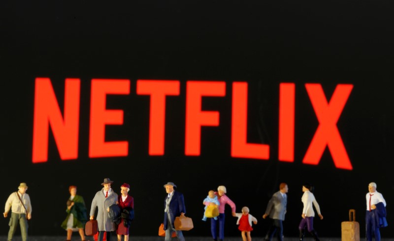 © Reuters. Small toy figures are seen in front of diplayed Netflix logo