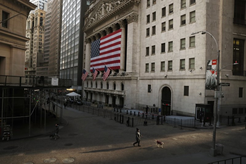 © Reuters. A pedestrian walks on Wall St., as concerns about coronavirus disease (COVID-19) keep more people at home, in front of the NYSE in New York