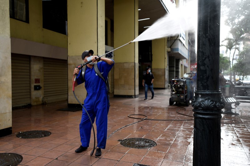 © Reuters. FILE PHOTO: A municipal worker cleans with a power washer after Ecuador's government restricted travel within the country and declared a nighttime curfew as a response to the coronavirus disease (COVID-19), in Guayaquil