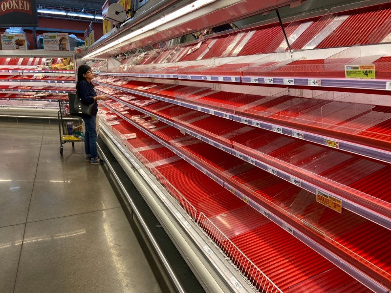 © Reuters. FILE PHOTO: A shopper picks over the few items remaining in the meat section, as people stock up on supplies amid coronavirus fears, at an Austin, Texas