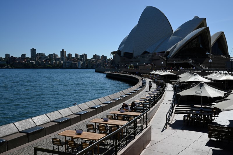 © Reuters. Tables at an open restaurant are seen mostly deserted on a quiet morning at the waterfront of the Sydney Opera House in Sydney