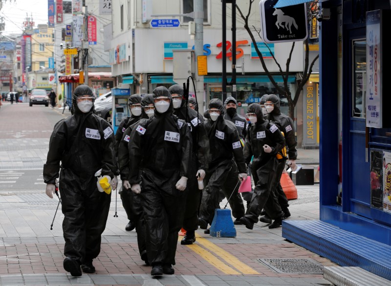 © Reuters. South Korean soldiers in protective gear make their way while they disinfect buildings downtown, following the rise in confirmed cases of coronavirus disease (COVID-19) in Daegu