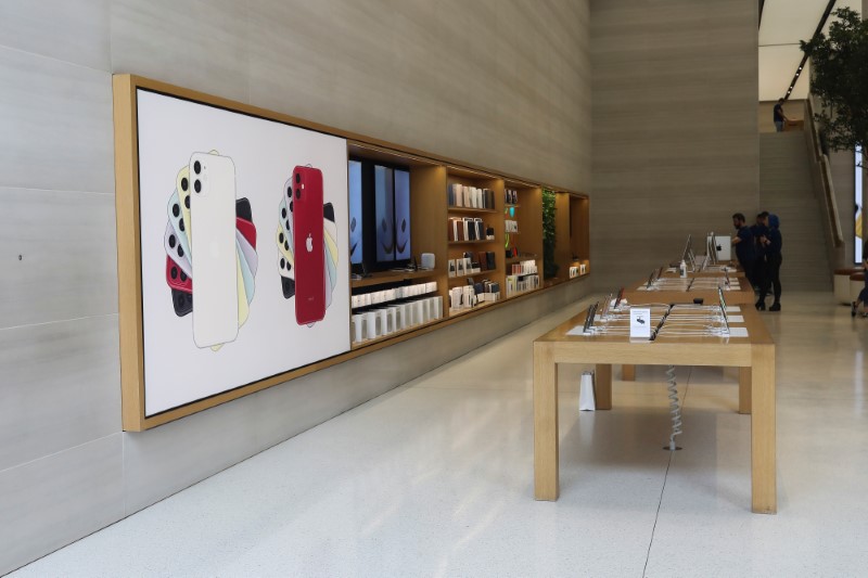 © Reuters. FILE PHOTO: Staff stand in an Apple store with no customers after it was closed on Regents Street in London