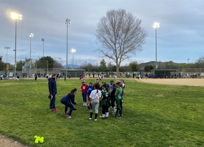 © Reuters. Players on the U.S. Olympic softball team instruct youth players during a clinic it hosted at Santee, California