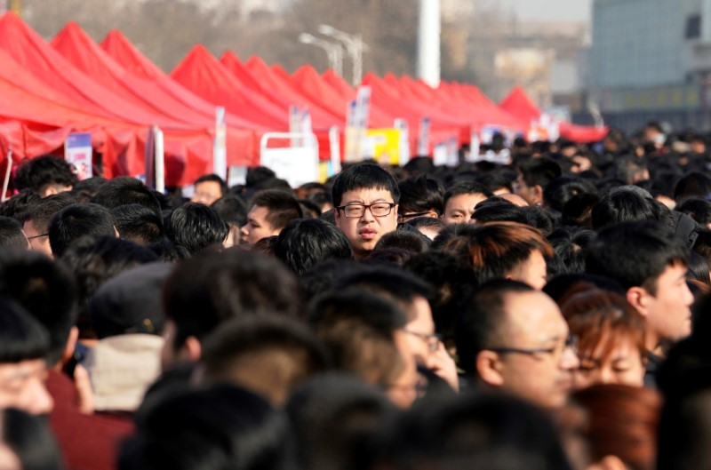 © Reuters. Job seekers crowd a job fair at Liberation Square in Shijiazhuang