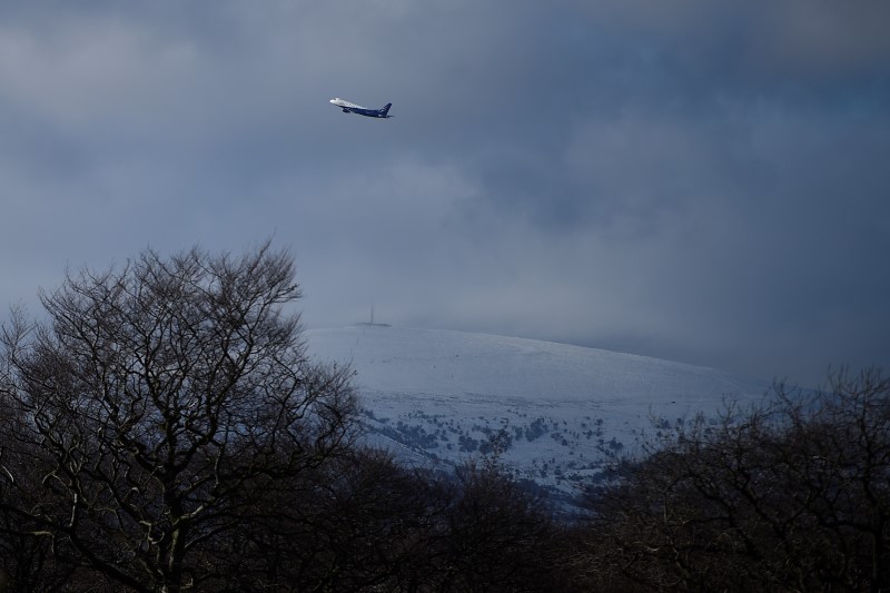 © Reuters. An aeroplane takes off over a snow capped mountain as seen from Stormont in Belfast