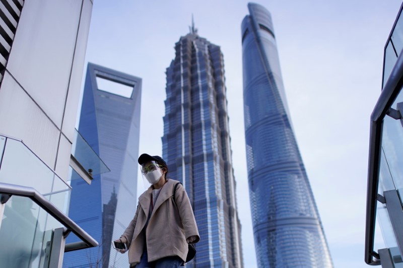 © Reuters. A woman wears a protective face mask, following an outbreak of the novel coronavirus disease (COVID-19), at Lujiazui financial district in Shanghai