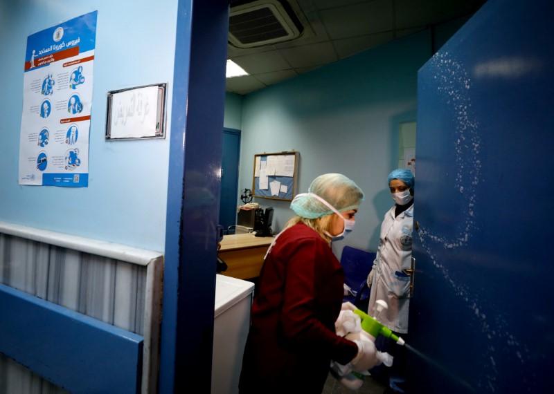 © Reuters. A worker sanitises a door at a hospital, as hospitals enforce a series of measures to prevent the spread of the coronavirus disease (COVID-19), in Damascus