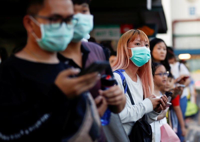 © Reuters. FILE PHOTO: Commuters wait for a transport to leave the Woodlands Causeway across to Singapore from Johor, hours before Malaysia imposes a lockdown on travel due to the coronavirus outbreak