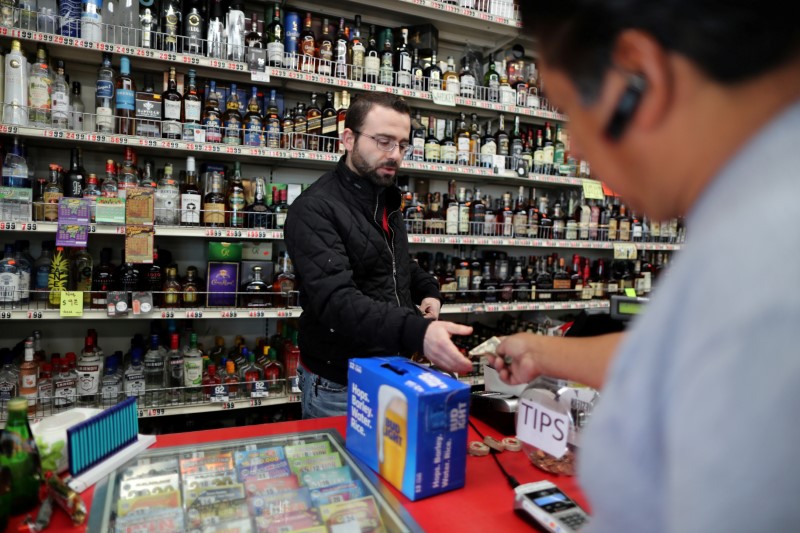 © Reuters. FILE PHOTO: Ibrahim Yacop, 36, owner of 7 Days Liquor, sells beer to a customer during the global outbreak of coronavirus disease (COVID-19) in Glendale