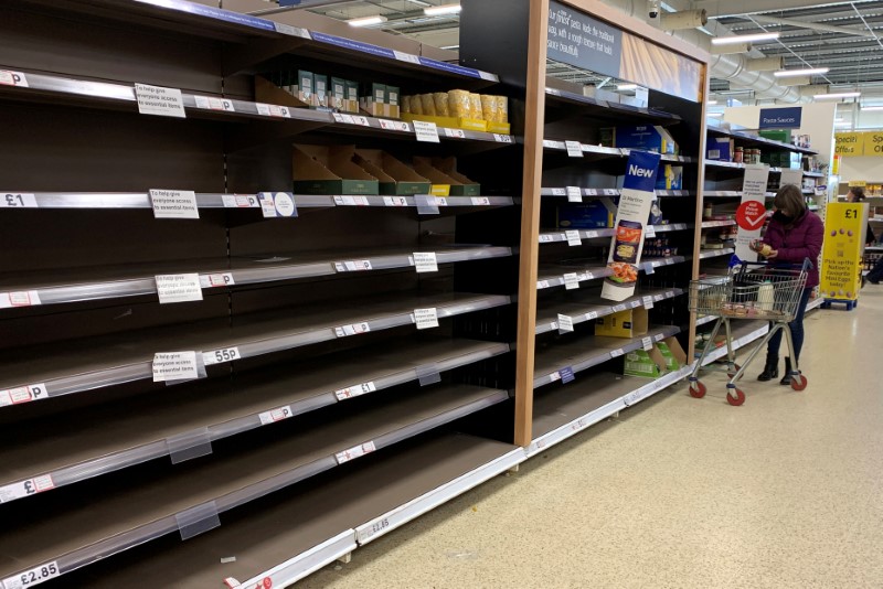 &copy; Reuters. A woman pushes her trolley along the empty pasta aisle inside a Tesco supermarket amid the coronavirus disease (COVID-19) outbreak in Manchester