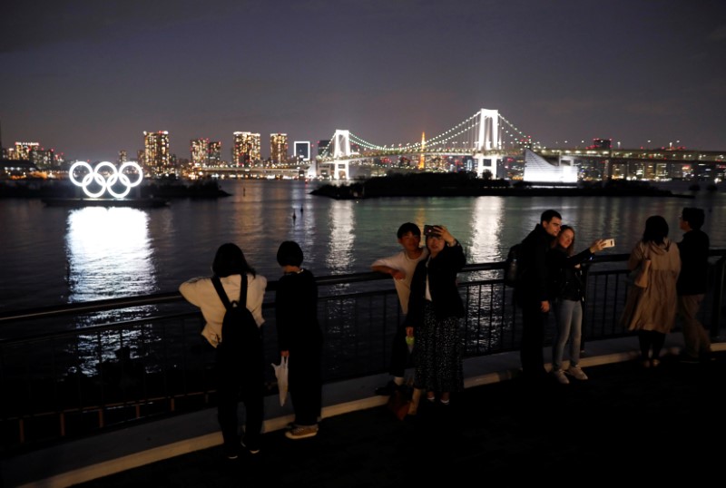 &copy; Reuters. People take selfies in front of the giant Olympic rings at the waterfront area at Odaiba Marine Park in Tokyo