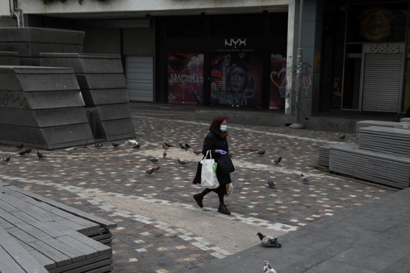 &copy; Reuters. A woman wearing a protective face mask makes her way on Monastiraki square, following an outbreak of the coronavirus disease (COVID-19), in Athens