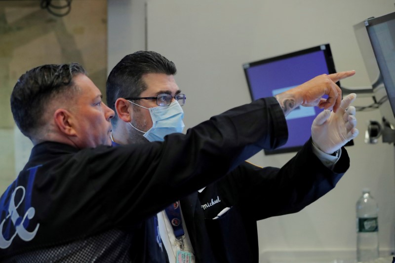 &copy; Reuters. FILE PHOTO: Traders work on the floor of the New York Stock Exchange (NYSE) as the building prepares to close indefinitely due to the coronavirus disease (COVID-19) outbreak in New York