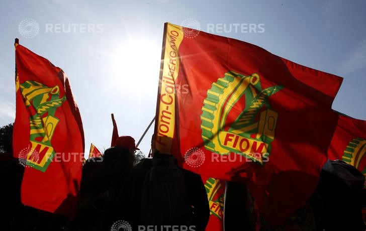 &copy; Reuters. Alcuni operai tengono in mano delle bandiere della FIOM durante uno sciopero a Roma.