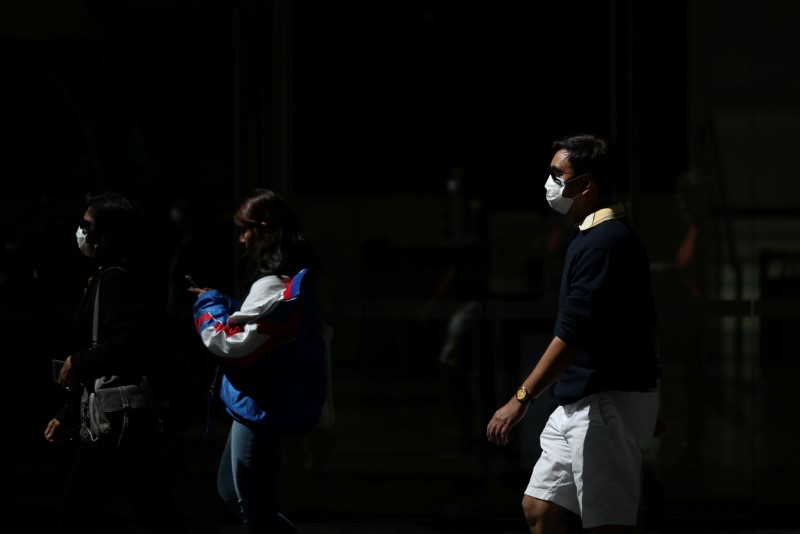 &copy; Reuters. FILE PHOTO: Pedestrians wear protective face masks amidst fears of the coronavirus disease (COVID-19) in Sydney