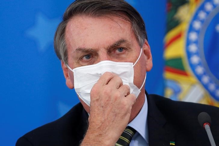 &copy; Reuters. Presidente Jair Bolsonaro utiliza máscara de proteção contra coronavírus durante coletiva de imprensa