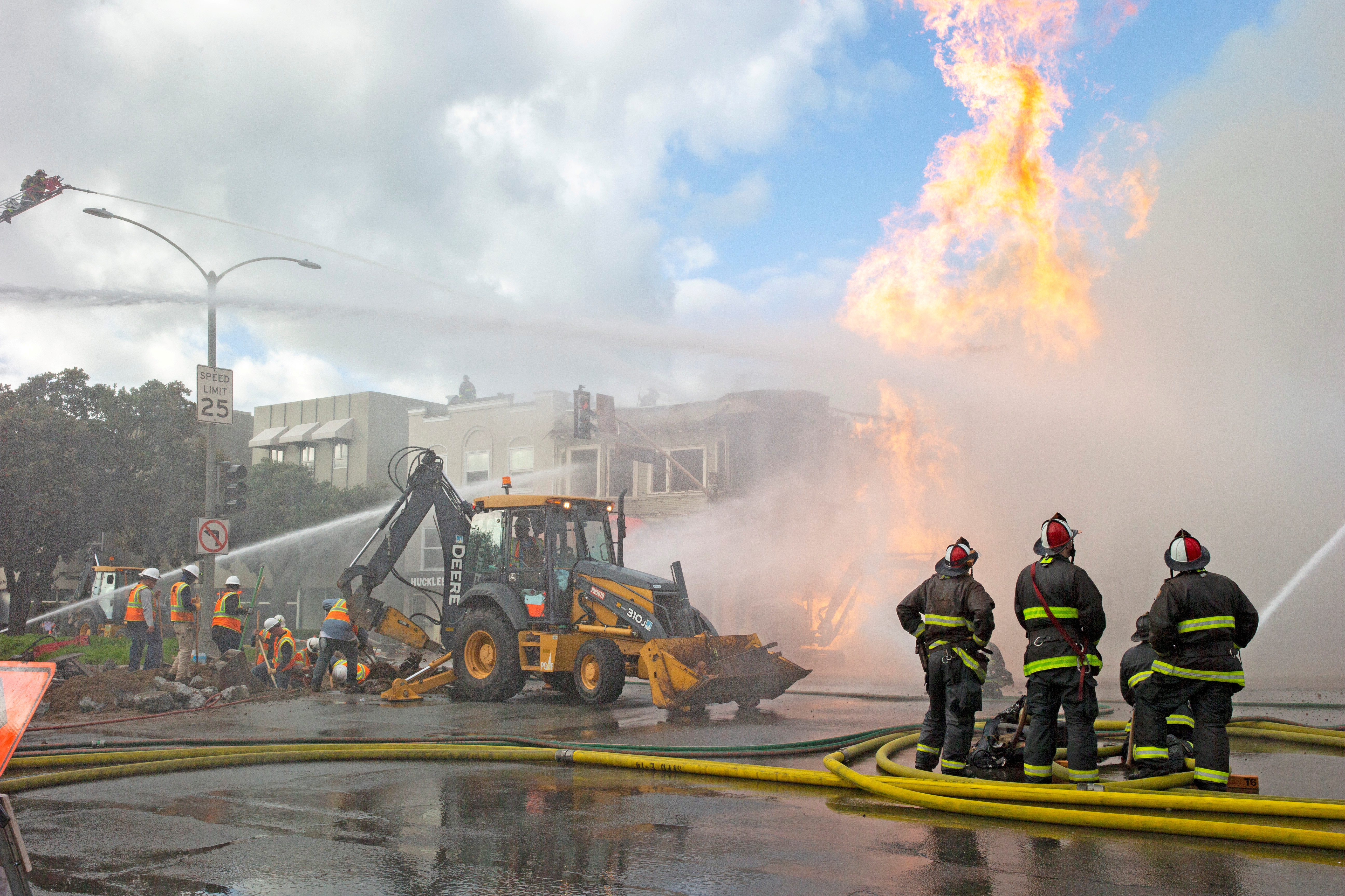 © Reuters. FILE PHOTO: Firefighters battle a fire following an explosion at Geary Boulevard and Parker Avenue as PG&E officials dig up the ground to reach the pipe in San Francisco