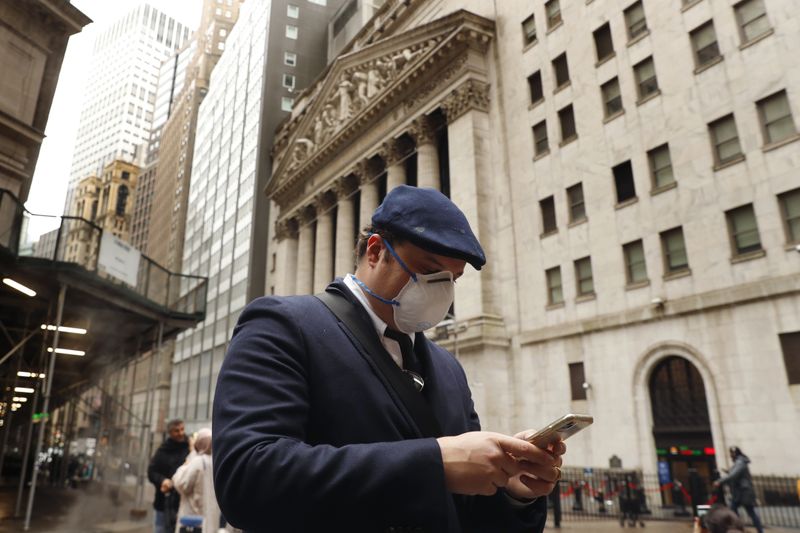 &copy; Reuters. Человек в защитной маске на фоне здания Нью-Йоркской фондовой биржи