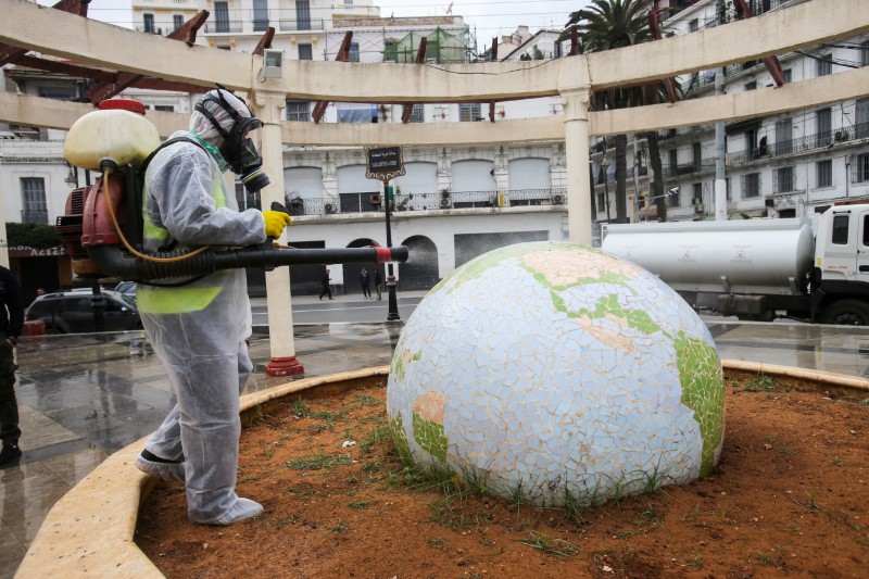&copy; Reuters. Un trabajador con un traje protector desinfecta un jardín público en Argel.