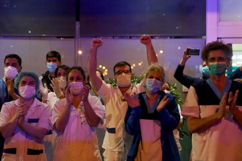 &copy; Reuters. Medical staff from the Fundacion Jimenez Diaz hospital applaud as neighbours applaud from their balconies in support for healthcare workers, during the coronavirus disease (COVID-19) outbreak, in Madrid