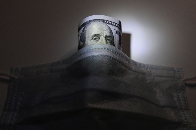 © Reuters. FOTO DE ARCHIVO: en esta ilustración se muestra un billete de dólar estadounidense detrás de una máscara protectora