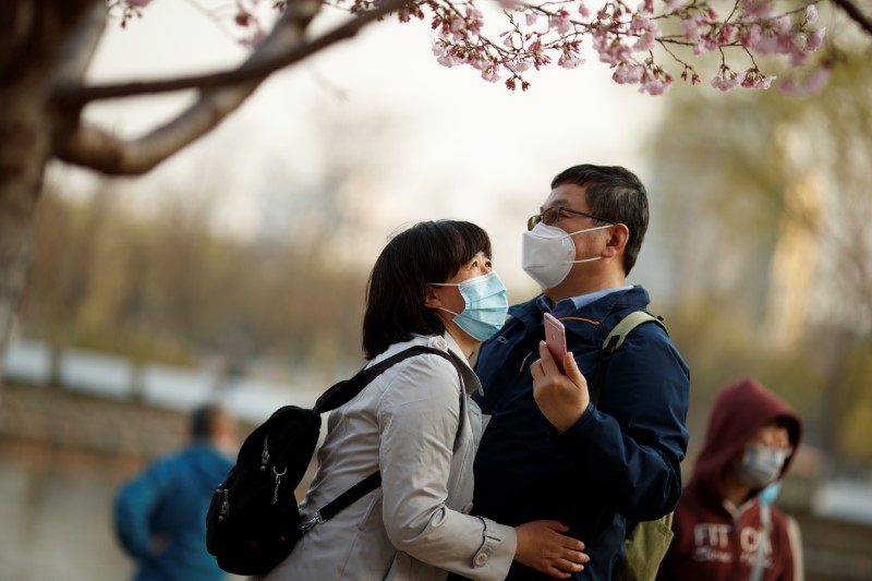 &copy; Reuters. Gente con mascarillas protectoras mientras se relacionan en un parque, mientras el país es azotado por un brote del nuevo coronavirus (COVID-19), en Pekín