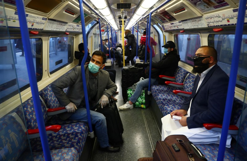 &copy; Reuters. Viajeros con máscaras faciales de protección mientras viajan en un tren de la línea Piccadilly durante la propagación del coronavirus en Londres