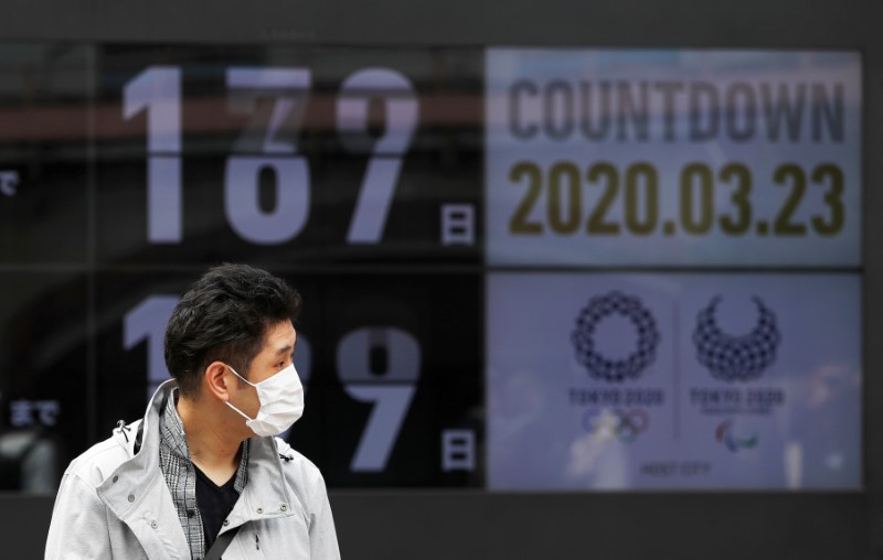 &copy; Reuters. FOTO DE ARCHIVO. Un peaton, que usa una mascarilla protectora debido a la pandemia del coronavirus (COVID-19), camina por una pantalla con cuenta regresiva para el inicio de los Juegos Olímpicos de Tokio 2020, en Tokio, Japón.