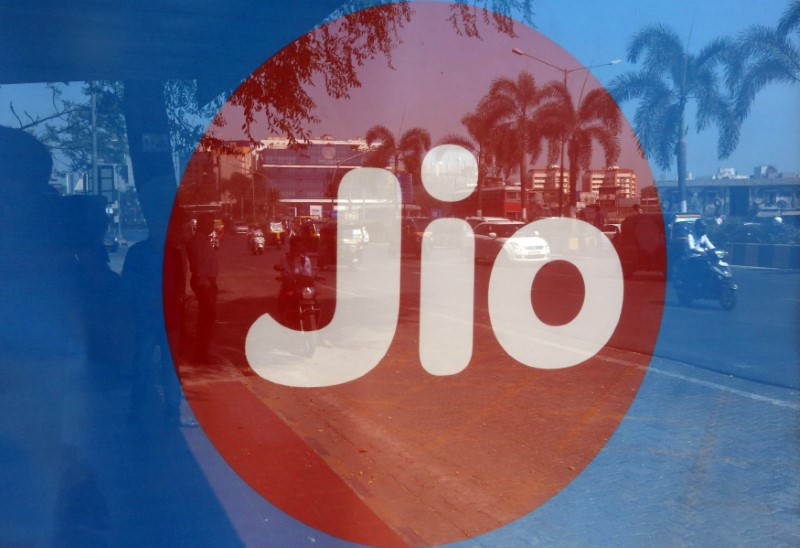 &copy; Reuters. Commuters are reflected on an advertisement of Reliance Industries&apos; Jio telecoms unit, at a bus stop in Mumbai