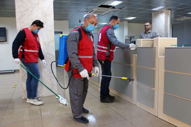 &copy; Reuters. Members of Red Crescent spray disinfectants at government offices in Misrata