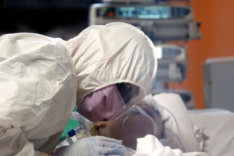 &copy; Reuters. Profissional médico com roupa de proteção atende paciente do novo coronavírus em hospital de Roma