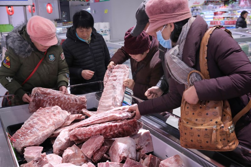 &copy; Reuters. Consumidores selecionam carne de porco congelada, liberada das reservas estatais, em Nantong, China