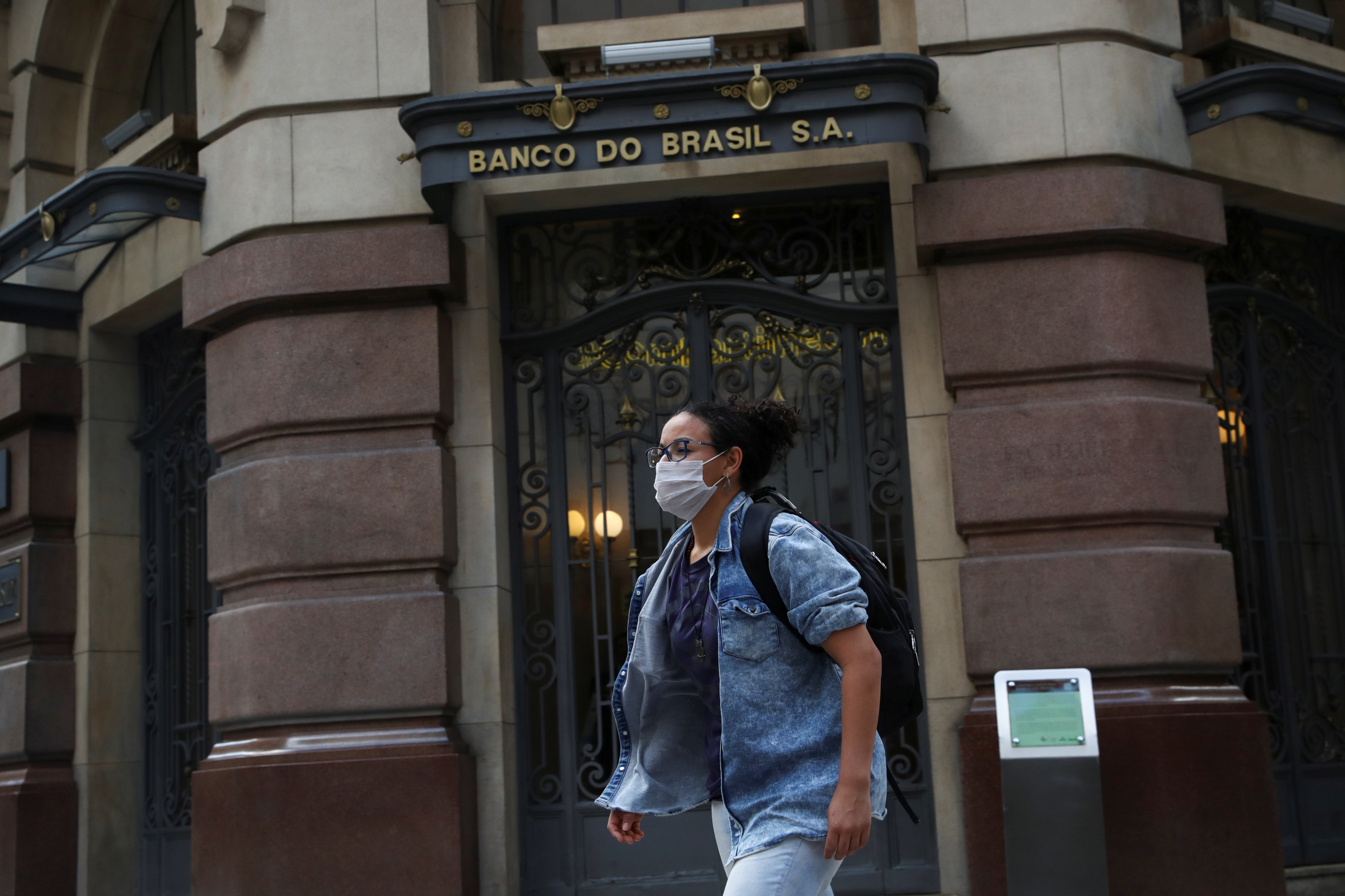 &copy; Reuters. A woman wearing a protective face mask walks in front of Banco do Brasil (Bank of Brazil) cultural building during the coronavirus disease (COVID-19) outbreak in Sao Paulo