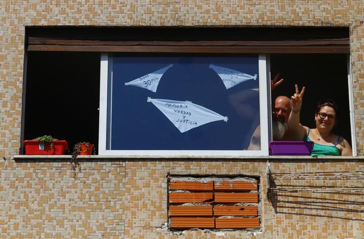 &copy; Reuters. Foto del martes de una mujer y un hombre en un balcón en Buenos Aires con pañuelos blancos en su ventana en la convocatoria online a recordar a los fallecidos en la última dictadura militar en Argentina