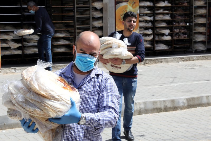 © Reuters. Workers load bread on a bus to sell it to people close to their homes after Jordan announced it would extend a curfew indefinitely, amid concerns over the spread of coronavirus disease (COVID-19), in Amman