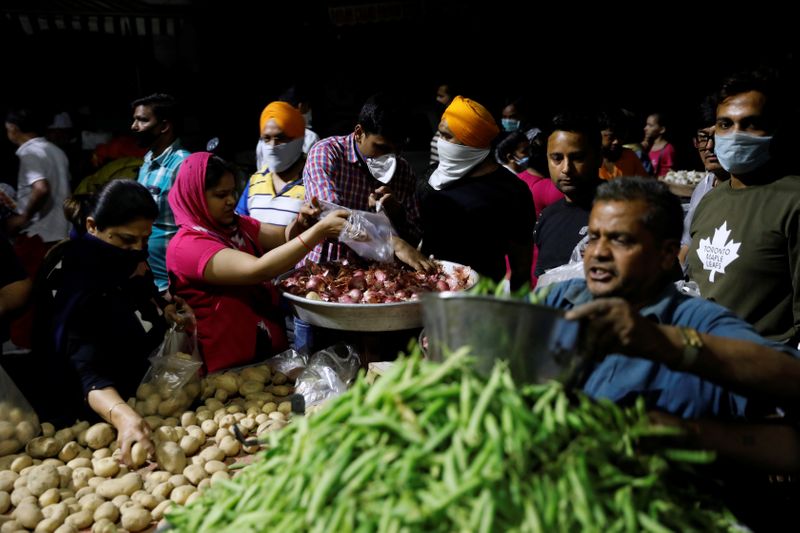 &copy; Reuters. People buy vegetables at a market after India&apos;s Prime Minister Narendra Modi called for a nationwide lockdown starting midnight to limit the spreading of coronavirus disease (COVID-19), in New Delhi