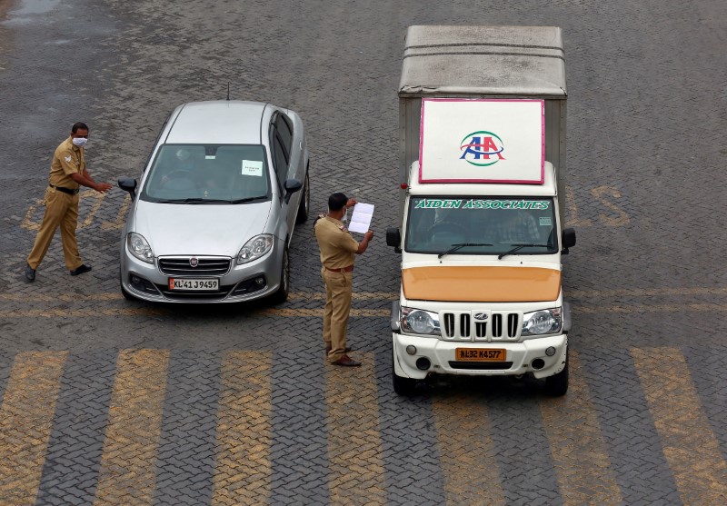 &copy; Reuters. Police officers stop vehicles and check their papers on a highway during 21-day nationwide lockdown to limit the spreading of coronavirus disease (COVID-19), in Kochi