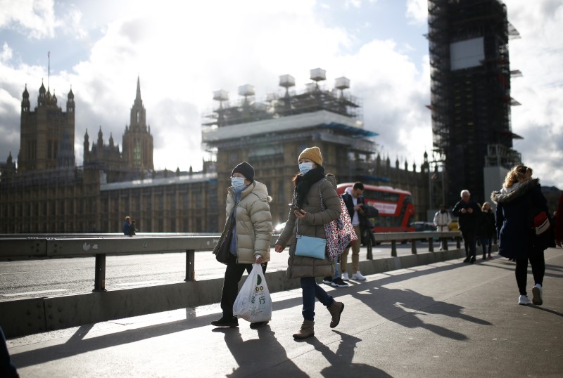 &copy; Reuters. FOTO DE ARCHIVO: El Parlamento británico es visto mientras personas con máscaras protectoras de la cara caminan a través del puente de Westminster, mientras el número de casos de coronavirus (COVID-19) alrededor del mundo continúa creciendo, en Londr